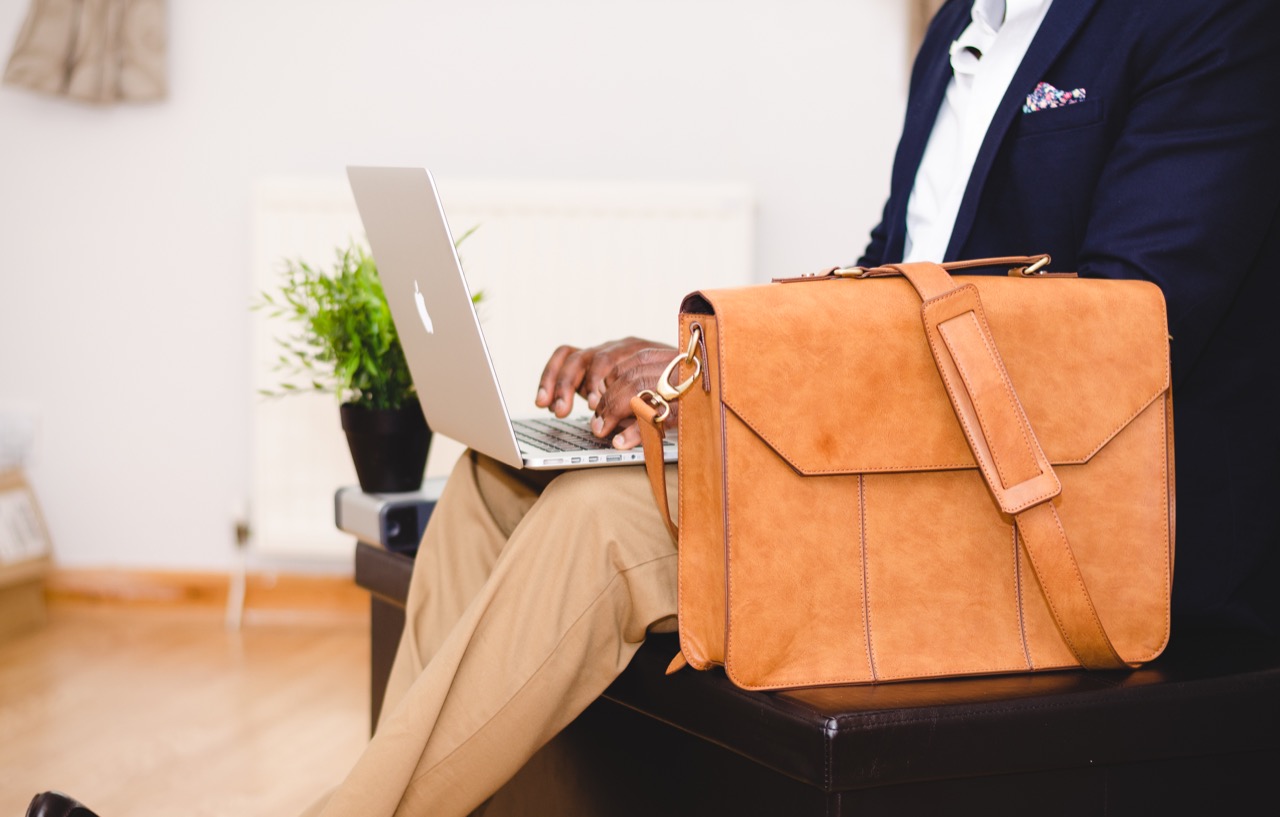 A professional working on a laptop during a business conversation